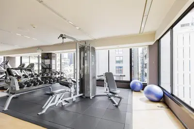 a gym with exercise equipment and large windows at Relaxing place in Downtown, BKK in Bangkok