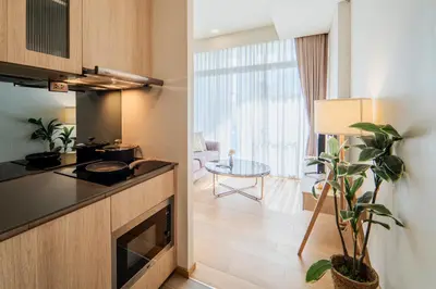 a kitchen with a counter and a table in a room at Panoramic 2BR Ekkamai with infinity pool in Bangkok