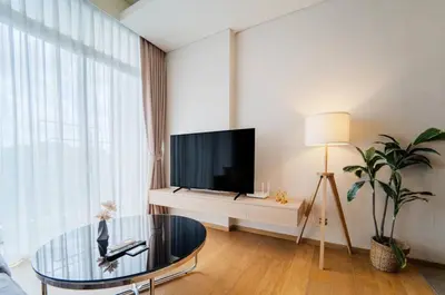 a living room with a tv and a glass table at Panoramic 2BR Ekkamai with infinity pool in Bangkok