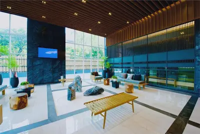 a lobby of a building with benches and windows at Panoramic 2BR Ekkamai with infinity pool in Bangkok