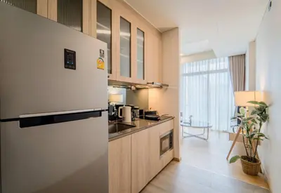 a kitchen with a refrigerator and a sink in a room at Panoramic 2BR Ekkamai with infinity pool in Bangkok