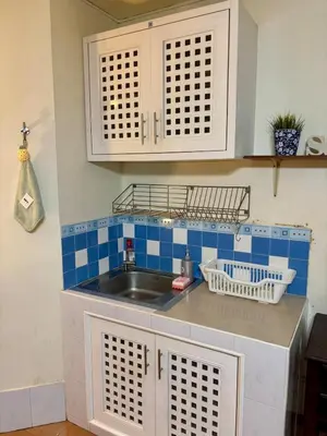 a kitchen with a sink and blue tiled wall at Ally home 12 23 in Thung Si Kan