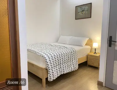 a small bedroom with a bed with a black and white blanket at Friend Nest Bangkok in Bangkok