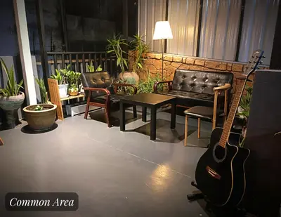 a living room with a guitar and a couch at Friend Nest Bangkok in Bangkok