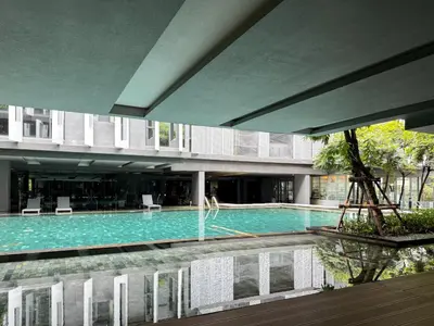 a large swimming pool in a building with a building at Expansive Luxury 2BR - Ultra Fast Wifi - Phrom Phong in Bangkok