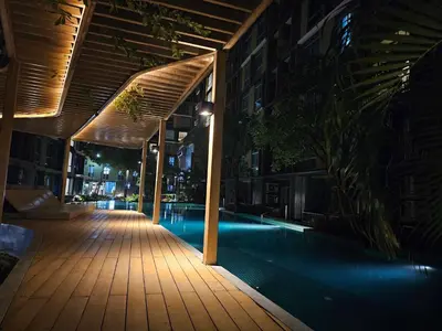 a building with a swimming pool at night at Metroluxe rama4 , city center in Bangkok