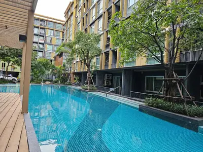 a large blue swimming pool next to a building at Metroluxe rama4 , city center in Bangkok