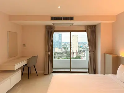 a bedroom with a bed and a desk and a window at Avana Residence in Bangna
