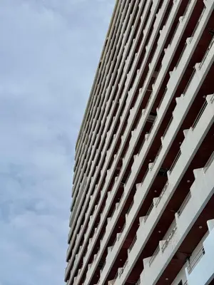 a tall white building with the sky in the background at Avana Residence in Bangna