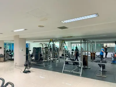 a gym with several tread machines and people in it at Avana Residence in Bangna