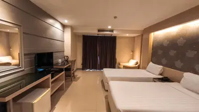 a hotel room with two beds and a television at Avana Residence in Bangna