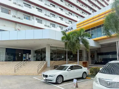 a white car parked in a parking lot in front of a building at Avana Residence in Bangna