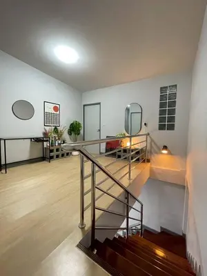 a living room with a staircase and a mirror at Ananta House in Bang Su