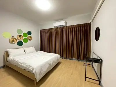 a bedroom with a white bed and a window at Ananta House in Bang Su