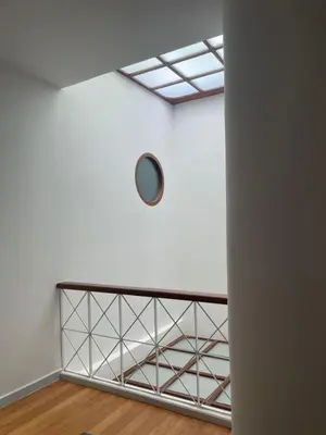a room with a white wall and a clock on the wall at Kin Bangkok in Bangkok