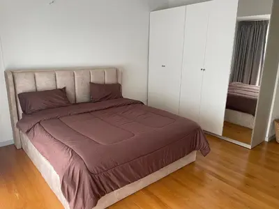 a bedroom with a large bed and white cabinets at Kin Bangkok in Bangkok