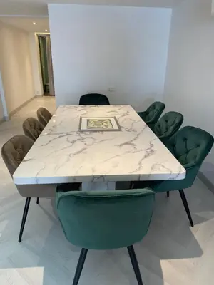 a table with green chairs and a white marble top at Kin Bangkok in Bangkok