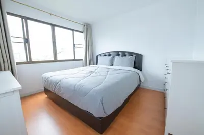 a bedroom with a bed with white sheets and windows at 2Bed Room Condo Near iConsiam & BTS Krungthonburi in Bangkok