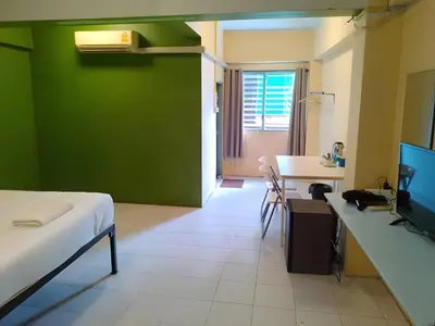 a room with a bed and a green wall at xx GO INN The Grand Palace - โก อินน์ วัดพระแก้ว พระบรมมหาราชวัง Pro in Bangkok