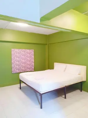a bed in a room with a green wall at xx GO INN The Grand Palace - โก อินน์ วัดพระแก้ว พระบรมมหาราชวัง Pro in Bangkok