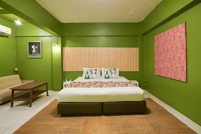 a green bedroom with a bed and a desk at xx GO INN The Grand Palace - โก อินน์ วัดพระแก้ว พระบรมมหาราชวัง Pro in Bangkok