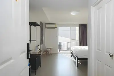 a bedroom with a bed and a balcony at XX Mitr Inn MRT Samyot - ตรอกวิสูตร MRT สามยอด in Bangkok