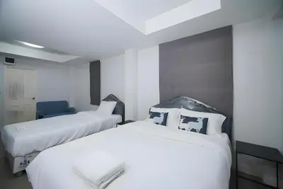 two beds in a room with white walls at XX Mitr Inn MRT Samyot - ตรอกวิสูตร MRT สามยอด in Bangkok