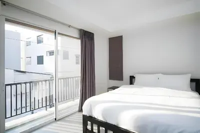 a bedroom with a bed and a large window at XX Mitr Inn MRT Samyot - ตรอกวิสูตร MRT สามยอด in Bangkok