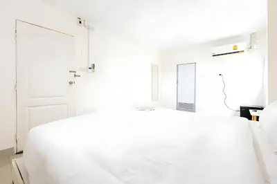 a white bedroom with a bed and a mirror at XX Oh My Nap Sukhumvit 3 - สุขุมวิท 3 in Makkasan
