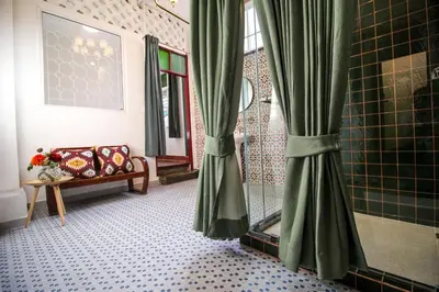 a bathroom with a shower with green curtains at The Open House Cafe and Hostel in Bangkok