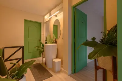 a hallway with green doors and a sink and plants at 4BR 10PAX 2min 7Eleven & 7min Commons Thonglor in Sathani Khlong Tan