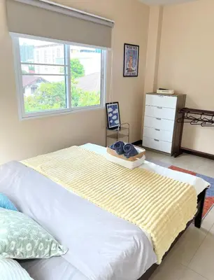a bedroom with a large bed with a window at Everything Within Minutes House in Bangkok