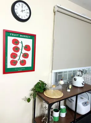 a clock hanging on a wall above a counter with a shelf at Everything Within Minutes House in Bangkok