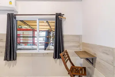 a room with a window and a wooden chair at Room 1 Homestay Near BTS Bangwa & Train Muaythai in Bangkok