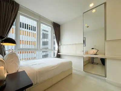 a bedroom with a bed and a desk and a window at Modern Stay Near ICONSIAM l Steps to BTS Krung Thon Buri l Ultra Fast WiFi in Bangkok