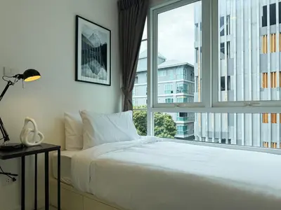 a bedroom with a white bed and a large window at Modern Stay Near ICONSIAM l Steps to BTS Krung Thon Buri l Ultra Fast WiFi in Bangkok