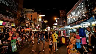 a crowd of people walking through a market at night at XX GO INN Khaosan โก อินน์ ตรอกข้าวสาร in Bang Bua Thong Railway Station