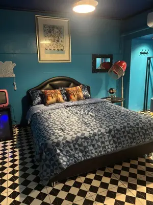 a bedroom with a bed with blue walls and a checkered floor at The oasis on 8 City blue 2