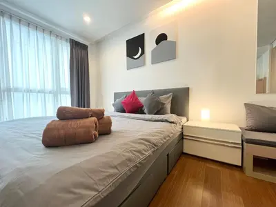 a bedroom with a large bed with a window at Private Comfy Near BTS&MRT Sukhumvit Minimum 14 nights in Bangkok