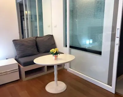 a living room with a table and a couch at Private Comfy Near BTS&MRT Sukhumvit Minimum 14 nights in Bangkok