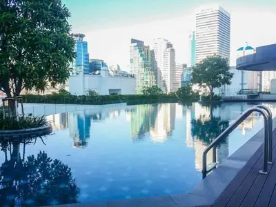 a swimming pool with a city in the background at Private Comfy Near BTS&MRT Sukhumvit Minimum 14 nights in Bangkok