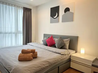 a bedroom with a bed with two pillows on it at Private Comfy Near BTS&MRT Sukhumvit Minimum 14 nights in Bangkok