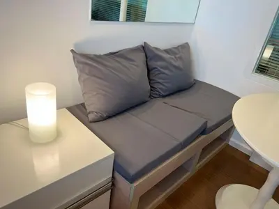a couch in a small room with a table at Private Comfy Near BTS&MRT Sukhumvit Minimum 14 nights in Bangkok