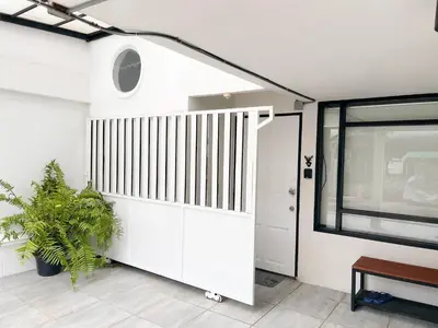 a white garage with a door and a window at 4BR 8PAX Near BTS Mochit MRT Chatuchak Union Mall in Sathani Bang Su
