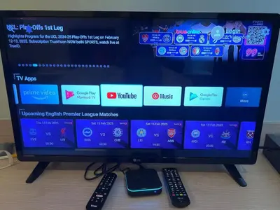 a computer monitor with two remote controls and a cell phone at Cozy Private Home I Steps to BTS & MRT Sukhumvit Minimum 14 nights in Bangkok
