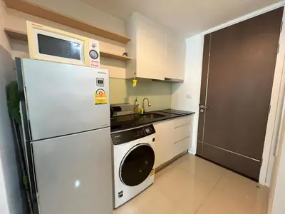 a kitchen with a microwave on top of a refrigerator at Cozy Private Home I Steps to BTS & MRT Sukhumvit Minimum 14 nights in Bangkok