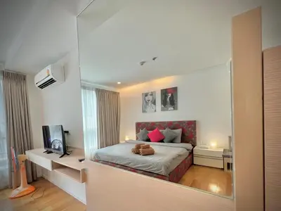a bedroom with a bed with a large mirror at Cozy Private Home I Steps to BTS & MRT Sukhumvit Minimum 14 nights in Bangkok