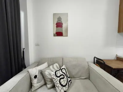 a living room with a couch with pillows and a lighthouse at Condo 1B1BR Sukhumvit 103 BTS Udomsuk in Phra Khanong