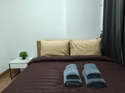 a bed with two blue towels on top of it at Condo 1B1BR Sukhumvit 103 BTS Udomsuk in Phra Khanong