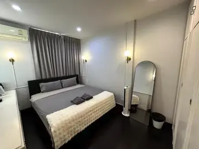 a bedroom with a large bed and a mirror at 4BR 12PAX 7min walk to Samitivej Sukhumvit Hospital in Khlong Toei